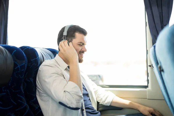 バスに座っている間 若い乗客はヘッドフォンで音楽を聞く — ストック写真
