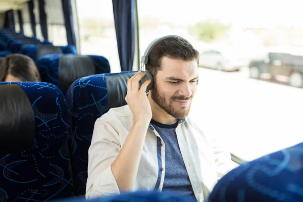 旅行バスでヘッドフォンで音楽を聴くヒスパニック旅行者 — ストック写真