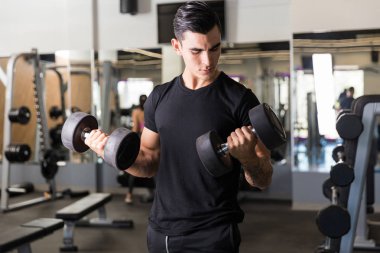 Kendini adamış erkek atlet sağlık kulübünde vücuduna bağlılığını gösteriyor
