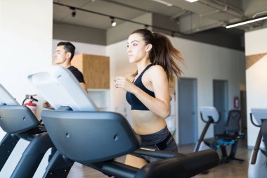 Fitness kadın spor salonunda bir koşu bandı üzerinde bir kardiyo oturumu yapıyor