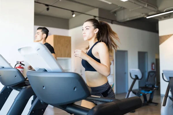 健身女性在健身房的跑步机上做有氧运动 — 图库照片