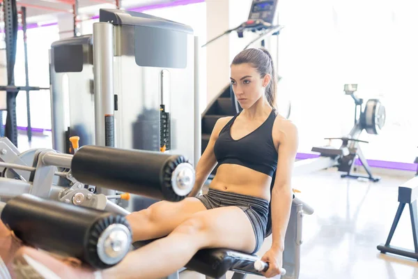 Spor Salonunda Bacak Uzatma Makinesi Ile Egzersiz Kendine Güvenen Kadın — Stok fotoğraf