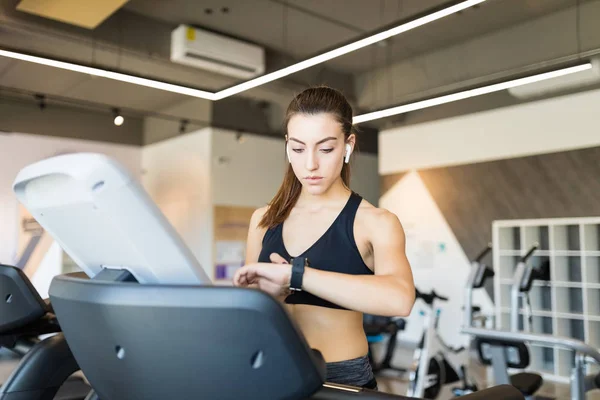 Sportif Genç Kadın Sağlık Kulübünde Egzersiz Makinesi Üzerinde Zaman Kontrol — Stok fotoğraf