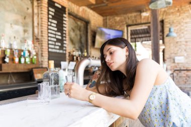 Barda tezgahta alkollü içecek olan depresif kadın