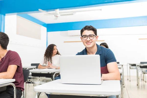 西班牙裔微笑的学生使用笔记本电脑 而坐在课堂上 在大学 — 图库照片