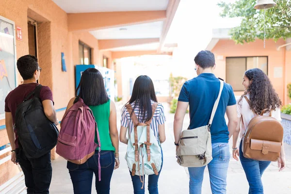 キャンパス内を歩くバックパックを持つ大学生の背面図 — ストック写真