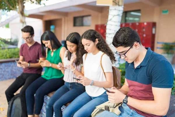 Grupa Przyjaciół Tekstylna Smartphone Siedząc Kampusie Uczelni — Zdjęcie stockowe