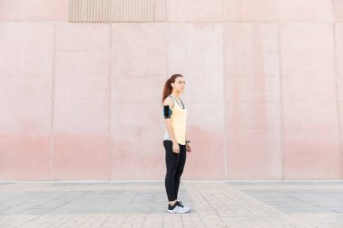 Kaldırım üzerinde büyüleyici fit kentsel Runner ayakta yan görünümü