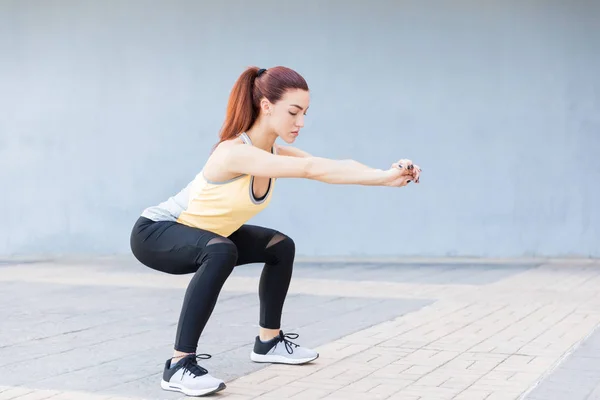 Beautiful Woman Performing Squatting Exercise While Stretching Hands Sidewalk — Stock Photo, Image