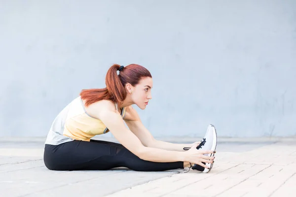 Side View Sporty Woman Bending While Sitting Footpath City — Stockfoto