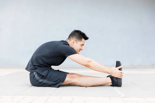 Motivated Concentrated Young Man Stretching Foot Doing Morning Exercise — Stock Photo, Image