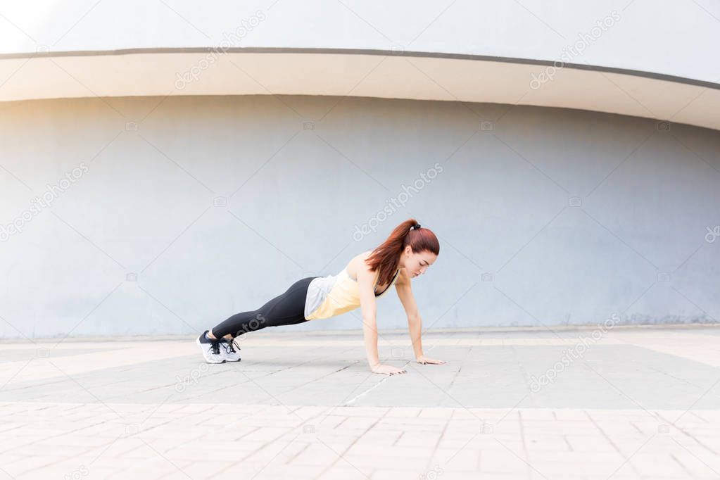 Full length of beautiful athlete exercising after jogging on footpath