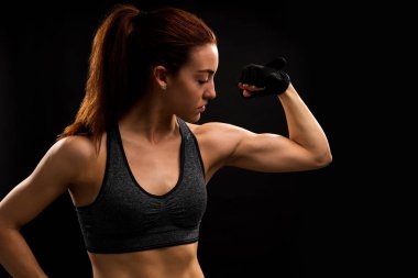 Genç fit kadın atlet izole arka plan karşı dururken kasları esneme