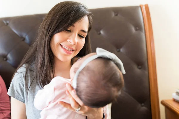 Sonriente Madre Llevando Linda Chica Mientras Está Sentado Dormitorio Casa — Foto de Stock