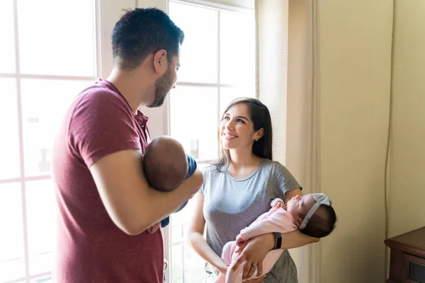 Pais Hispânicos Olhando Uns Para Outros Enquanto Carregam Bebês Casa — Fotografia de Stock