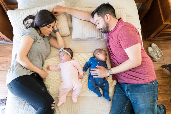 Evde Yatakta Ikiz Bebeklerle Yatan Ebeveynlerin Üst Görünümü — Stok fotoğraf
