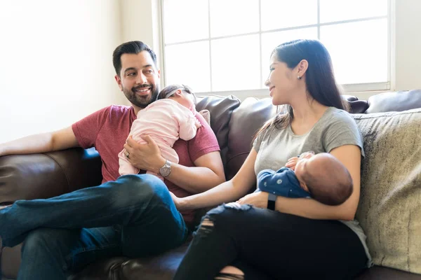 Lachende Ouders Die Elkaar Kijken Terwijl Samen Zitten Met Baby — Stockfoto