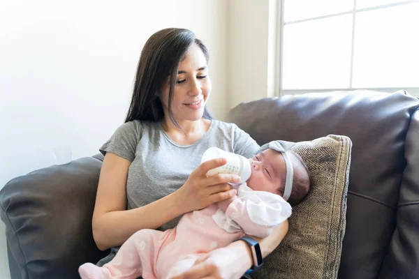 Mãe Adulta Média Alimentando Leite Para Sua Menina Mamadeira Sofá — Fotografia de Stock