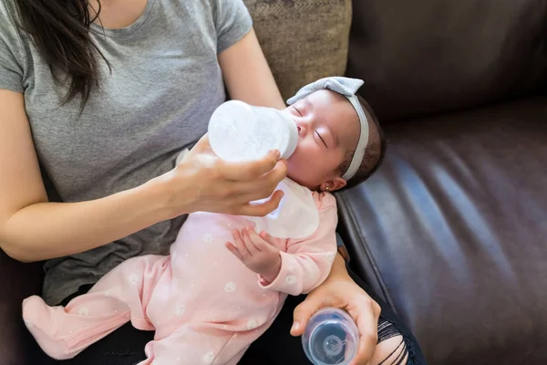 Mid Adult Mamma Utfodring Baby Flicka Med Flaska Soffan — Stockfoto