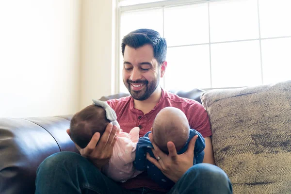 Lachende Latijnse Man Kijkt Naar Tweeling Baby Zittend Bank — Stockfoto