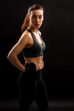 Kendine güvenen kadın atlet düz arka plan karşı kalça elleri ile ayakta