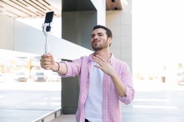 Alışveriş merkezinde akıllı telefonda Gülümseyen İspanyol vlogger streaming video