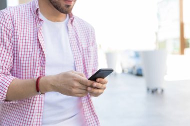 Alışveriş merkezinde akıllı telefon üzerinde online erkek blogger paylaşımı Orta bölümü