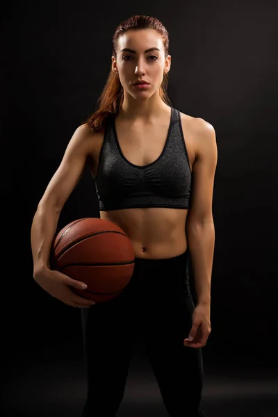 白人女篮球员拿着黑色背景球的肖像 — 图库照片