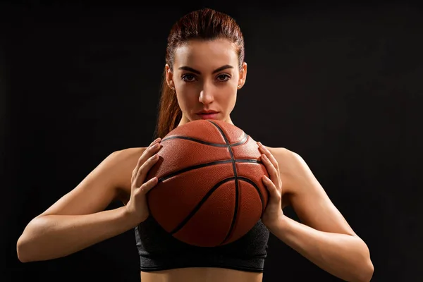 プレーンな背景に立ちながらバスケットボールボールを持つ若い魅力的な選手の肖像画 — ストック写真