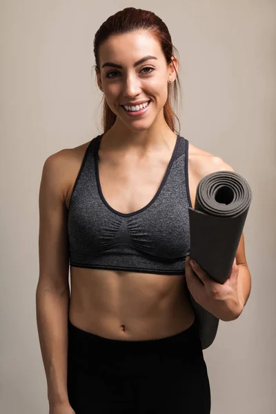 Retrato Mulher Jovem Sorrindo Segurando Tapete Exercício Enquanto Está Contra — Fotografia de Stock