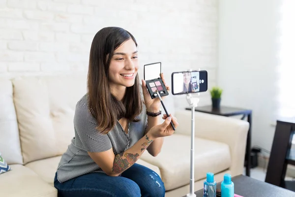 微笑拉丁影响者记录化妆视频的美容博客在智能手机 — 图库照片