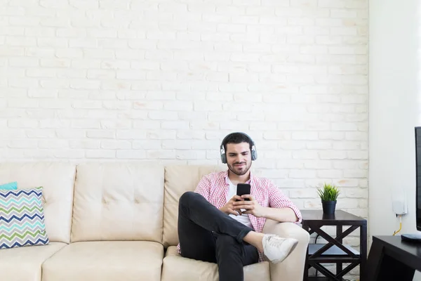 Young Vlogger Wearing Headphones While Using Mobile Phone Sofa — Stock Photo, Image