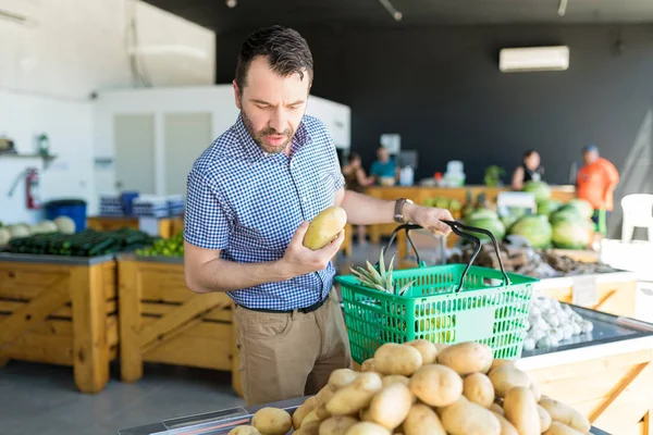 Homem Adulto Médio Cauteloso Olhando Para Batatas Empilhadas Durante Compras — Fotografia de Stock