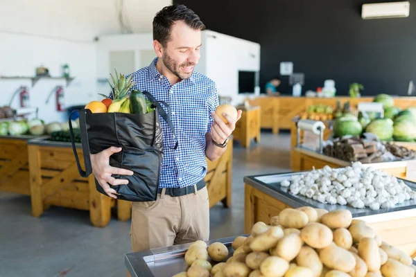 Mężczyzna Kupujący Noszenie Torby Zakupy Przy Wyborze Organicznych Ziemniaków Sklepie — Zdjęcie stockowe