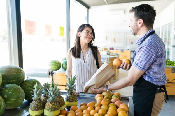 Dueño Tienda Comestibles Masculina Embalaje Naranjas Bolsa Papel Mientras Habla — Foto de Stock