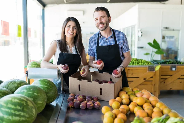 Männliche Und Weibliche Besitzer Arrangieren Frische Pfirsiche Auf Der Theke — Stockfoto