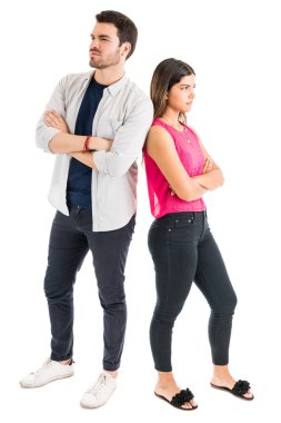 Kollar düz arka plan karşı çapraz arka arkaya ayakta rahatsız çift tam uzunlukta