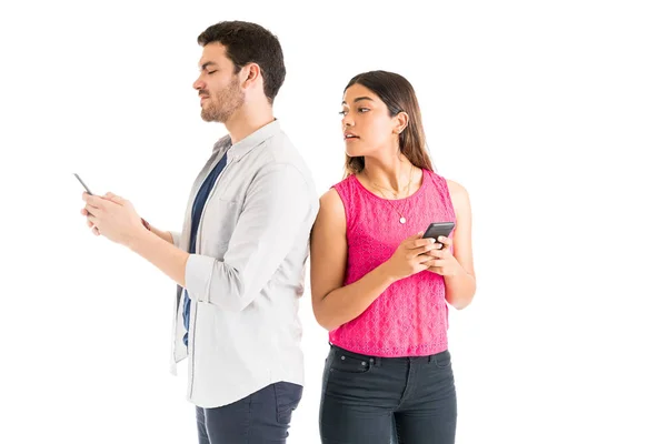 白い背景に立ちながら ボーイフレンドのテキストメッセージスマートフォンを覗く女性 — ストック写真