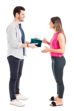 Beyaz arka plan karşı gülümseyen genç kız arkadaşı hediye veren adamın tam uzunlukta yan görünümü