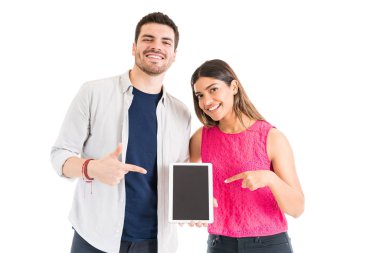 Stüdyoda kablosuz teknoloji tutarken gülümseyen erkek arkadaşı ve kız arkadaşı gesturing Portresi