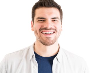 Düz arka plan karşı göz teması oluşturan gömlek giyen sakallı çekici İspanyol adam