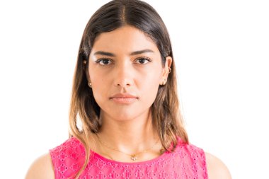 Stüdyoda göz teması kurarak ciddi yüz ile kendine güvenen genç Latin kadın