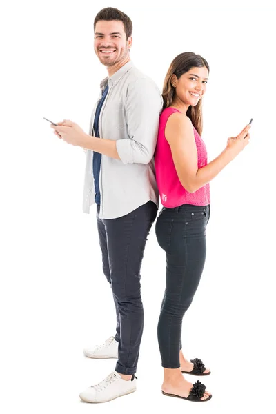 Comprimento Total Homem Mulher Sorrindo Usando Telefones Celulares Sobre Fundo — Fotografia de Stock