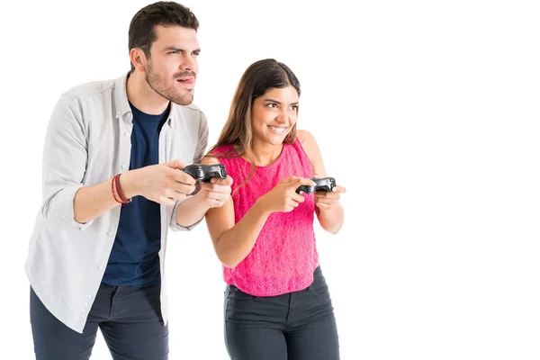 白い背景に対してビデオゲームをプレイしながら 若い魅力的な男女がお互いに競い合う — ストック写真