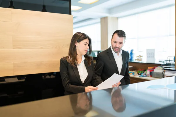 Mid Adult Latin Managers Discussing Document While Standing Front Desk — Stock Photo, Image