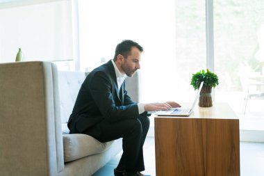 Otelde lobi otururken İspanyol satış temsilcisi laptop üzerinde posta kontrol