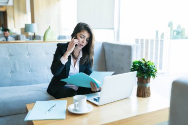 Otel lobisinde müşteri ile cep telefonda konuşurken güzel orta yetişkin saleswoman okuma belgesi