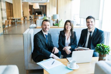 Toplantı sırasında lobide kanepede oturan çekici Ispanyol orta yetişkin iş arkadaşları portresi