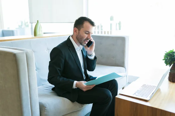 Confident Hispanic Manager Talking Cellphone Reading Business Plan While Sitting — Stock Photo, Image