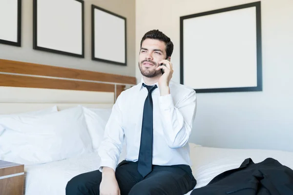 Knappe Mannelijke Executive Praten Smartphone Terwijl Zittend Bed Hotelkamer — Stockfoto